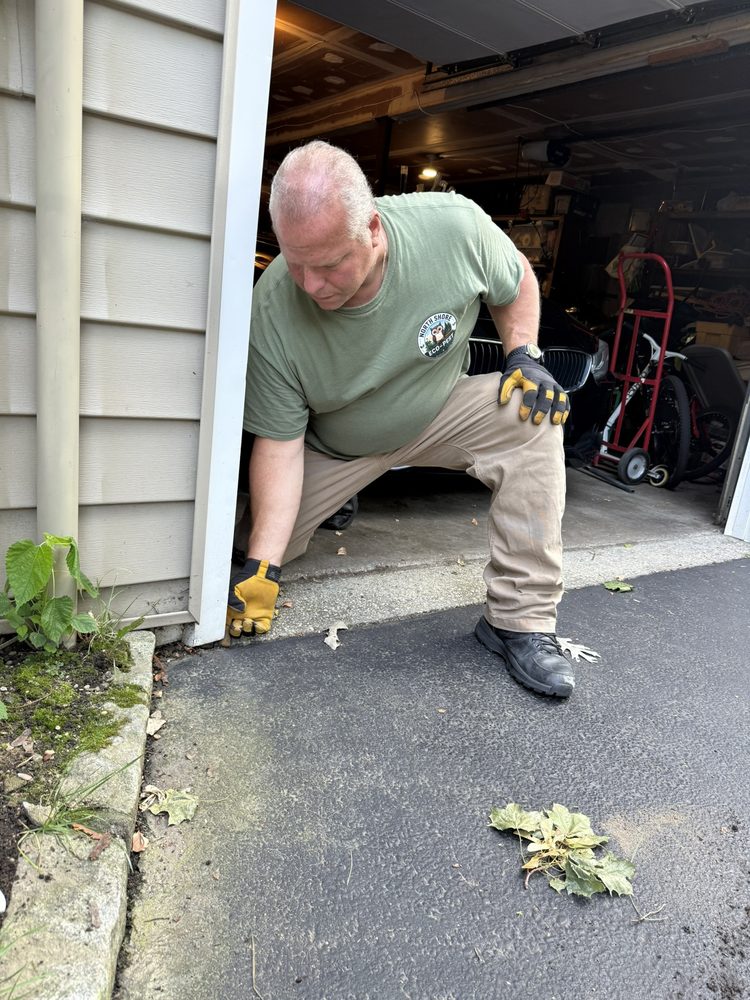 Steve Rocco Tardalo inspecting a garage door threshold on a North Shore property